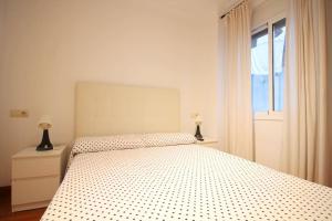 a white bedroom with a bed and a window at Triana Luxury Numancia in Seville