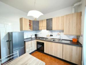 una cucina con armadi in legno e frigorifero in acciaio inossidabile di Casa Michi a Verbania