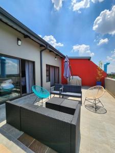 un patio con 2 sedie e un tavolo di Next To Apartment Hotel a Pretoria