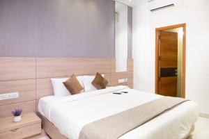 a bedroom with a large white bed with a wooden headboard at Hypons Hotel in Bengaluru +30 photos