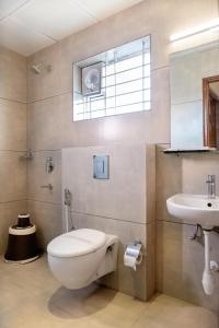 a bathroom with a toilet and a sink at Hypons Hotel in Bengaluru