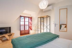 a bedroom with a bed and a tv and a window at Les Cahiers de Vacances in Amboise