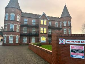 a large brick building with a sign in front of it at Auckland House 3 beds free parking in Doncaster