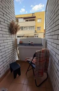 een balkon met een stoel en een tafel en een gebouw bij Lina's Apartment in Skopje