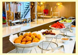 un buffet con diverse ciotole di arance e altri frutti di Aurora Hotel Măng Đen a Kon Von Kla