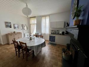 kuchnia i jadalnia ze stołem i krzesłami w obiekcie « La Souillarde » w mieście Saint-Médard-en-Jalles