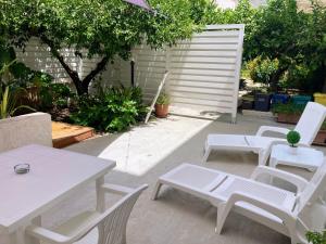 a group of white chairs and tables in a patio at Nonna n'Zina Trapani Casa Vacanza in Erice