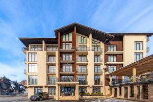 an apartment building with a car parked in front of it at Gold Palace Bukovel in Bukovel