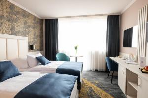um quarto de hotel com duas camas e uma secretária em Airport Hotel Budapest em Vecsés