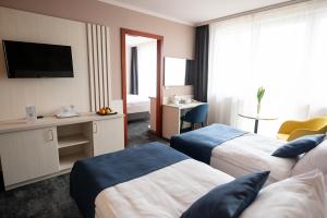 um quarto de hotel com duas camas e uma televisão em Airport Hotel Budapest em Vecsés