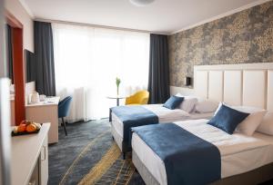 um quarto de hotel com duas camas e uma mesa em Airport Hotel Budapest em Vecsés