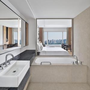 a bathroom with a tub and a large mirror at The Westin Mumbai Powai Lake in Mumbai