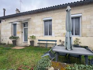 - un parasol installé sur une table dans la cour dans l'établissement « La Souillarde », à Saint-Médard-en-Jalles