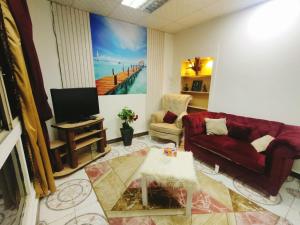 sala de estar con sofá rojo y TV en شقة مفروشة صف اول علي النيل بالمعادي بجوار هيلتون الكورنيش, en El Cairo