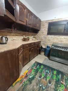 cocina con armarios de madera y alfombra de cocina en شقة مفروشة صف اول علي النيل بالمعادي بجوار هيلتون الكورنيش, en El Cairo