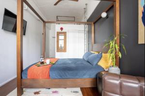 1 dormitorio con cama con dosel y sofá en Character Loft Studio in the Heart of City Centre en Auckland