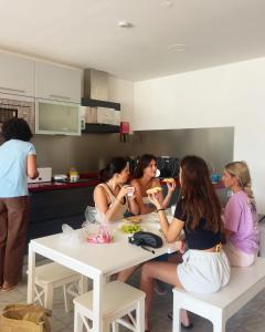 um grupo de mulheres sentadas em torno de uma mesa em uma cozinha em Arca Nova Guest House & Hostel Caminha em Caminha