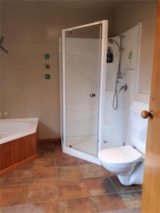 a bathroom with a shower and a toilet and a sink at The Arches Dunedin in Dunedin +7 photos