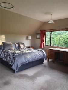 sypialnia z łóżkiem, biurkiem i oknem w obiekcie The Arches Dunedin w mieście Dunedin