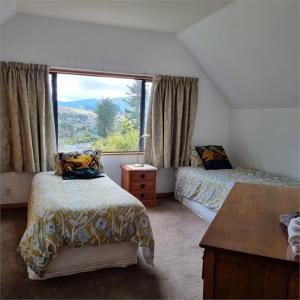 sypialnia z 2 łóżkami i dużym oknem w obiekcie The Arches Dunedin w mieście Dunedin