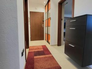 a hallway with a dresser and a door with a rug at Apartament u Tomka in Władysławowo
