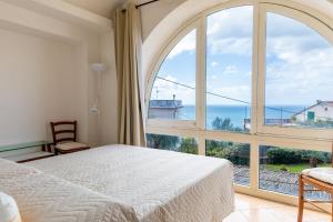 马萨鲁布朗斯Villa Marghe - Sea View Rooms的一间卧室，里面有一张床和一扇大窗户。
