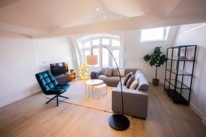 een woonkamer met een bank en een stoel bij Grandly 3 Bedroom Serviced Apartment 83m2 -NB306G- in Rotterdam