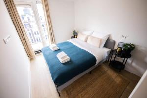 1 dormitorio con 1 cama grande y toallas. en Grandly 3 Bedroom Serviced Apartment 83m2 -NB306G- en Róterdam
