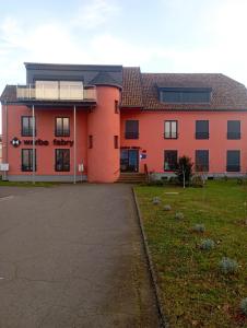 - un grand bâtiment orange avec une allée devant dans l'établissement Ferienwohnungen Fabry, à Sarrebruck