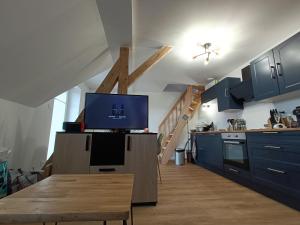 a kitchen with blue cabinets and a tv on a table at Duplex F2 au pied des pistes du lac blanc in Orbey