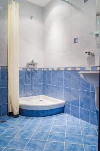 オブゾルにあるGaleria Holiday Apartmentsの青いタイル張りのバスルーム(バスタブ、シンク付)