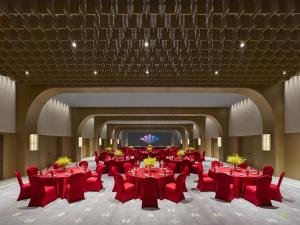 a large banquet hall with red tables and chairs at Maison Albar Hotels Leshan in Leshan