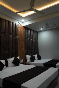 a bedroom with two beds and a wall with two beds at HOTEL PR VILLA in Gandhinagar