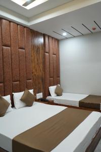 a room with two beds and a wall at HOTEL PR VILLA in Gandhinagar