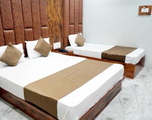 a couple of beds in a room at HOTEL PR VILLA in Gandhinagar