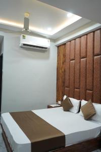 a bedroom with a large bed with a headboard at HOTEL PR VILLA in Gandhinagar