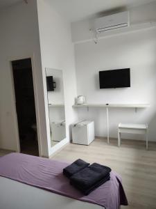 a white bedroom with a bed with two black towels at Bedaleyl in Piteşti