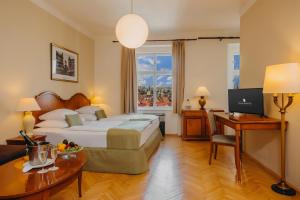 a hotel room with a bed and a desk at Wenceslas Square Hotel - Czech Leading Hotels in Prague