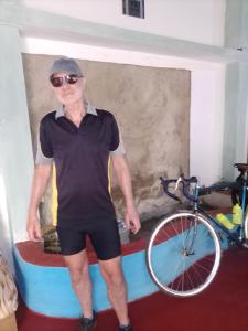 um homem ao lado de uma bicicleta num quarto em Our Little Secret em Kalutara