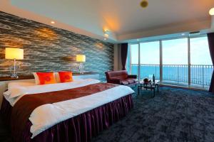Habitación de hotel con cama grande y ventana grande. en HOTEL CALM Leisure Hotel en Beppu