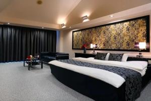 別府市にあるHOTEL CALM Leisure Hotelのベッドルーム(大型ベッド1台、ソファ付)