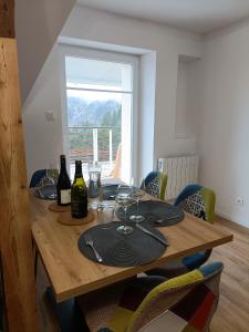 a wooden table with wine bottles and glasses on it at Duplex F2 au pied des pistes du lac blanc in Orbey