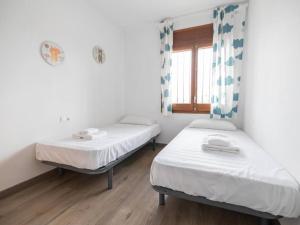 two beds in a room with a window at Espectacular casa con piscina en Tordera in Tordera