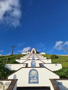 a church with a cross on top of a hill at Caminhos nos Levam pela Ilha in Ponta Delgada