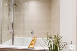 baño con ducha y bañera con planta en Charming 2-Bed with private balcony & free parking, en Dagenham