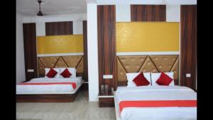 カトラにあるHotel Lords Paradise , Katraのベッドルーム1室(ベッド2台、赤と白の枕付)