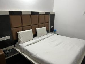 un grande letto con due cuscini bianchi di Hotel Lords Paradise , Katra a Katra