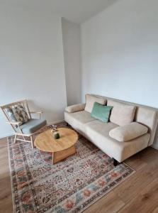 a living room with a couch and a table and a chair at Central Apartment with a Magnificent View in Graz
