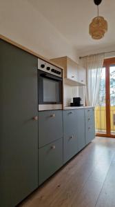 a kitchen with white cabinets and a stove top oven at Central Apartment with a Magnificent View in Graz