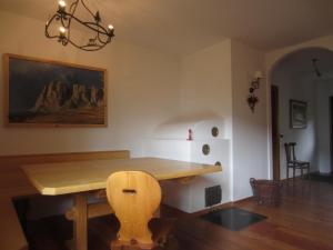 una sala da pranzo con tavolo in legno e lampadario pendente di Villa Cleila Verde B a San Vito di Cadore